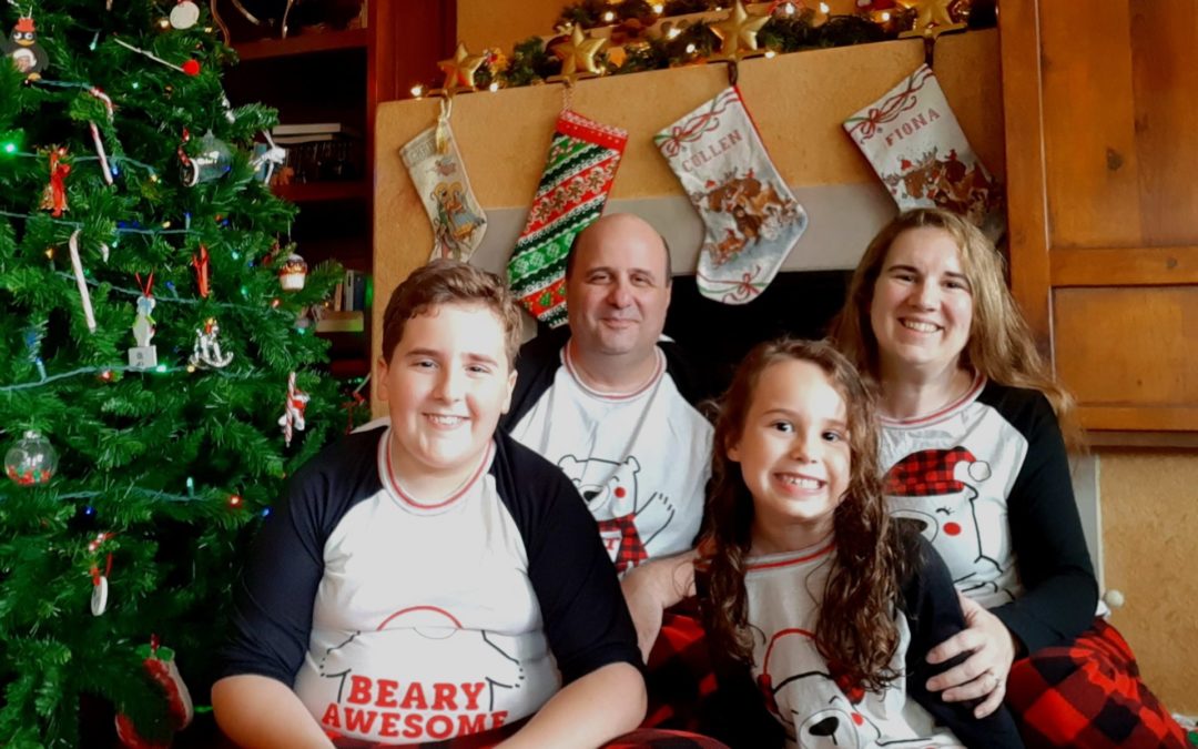 Larkins Family - Smiling family in front of Christmas stockings