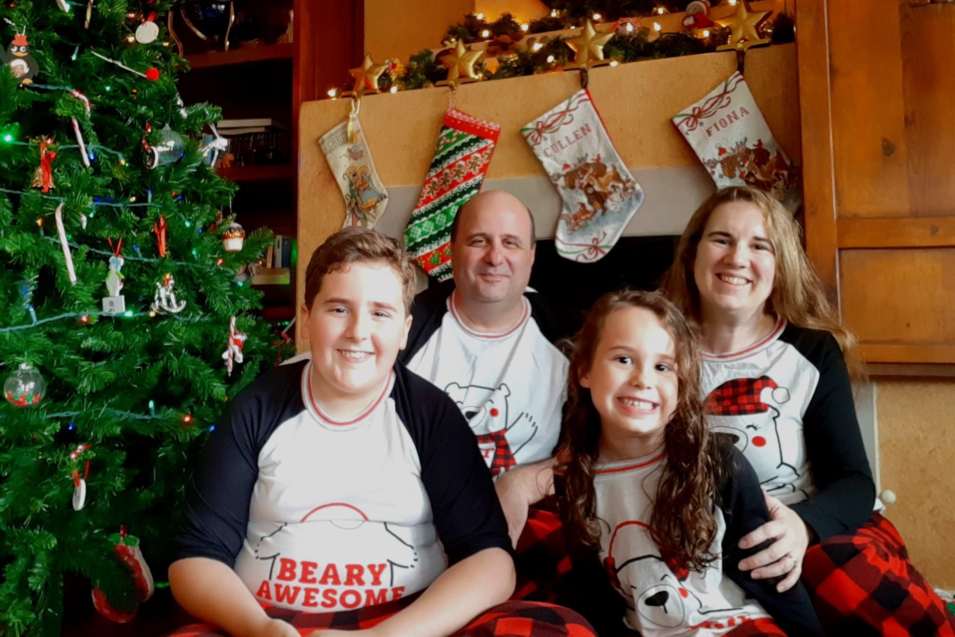 Larkins Family - Smiling family in front of Christmas stockings
