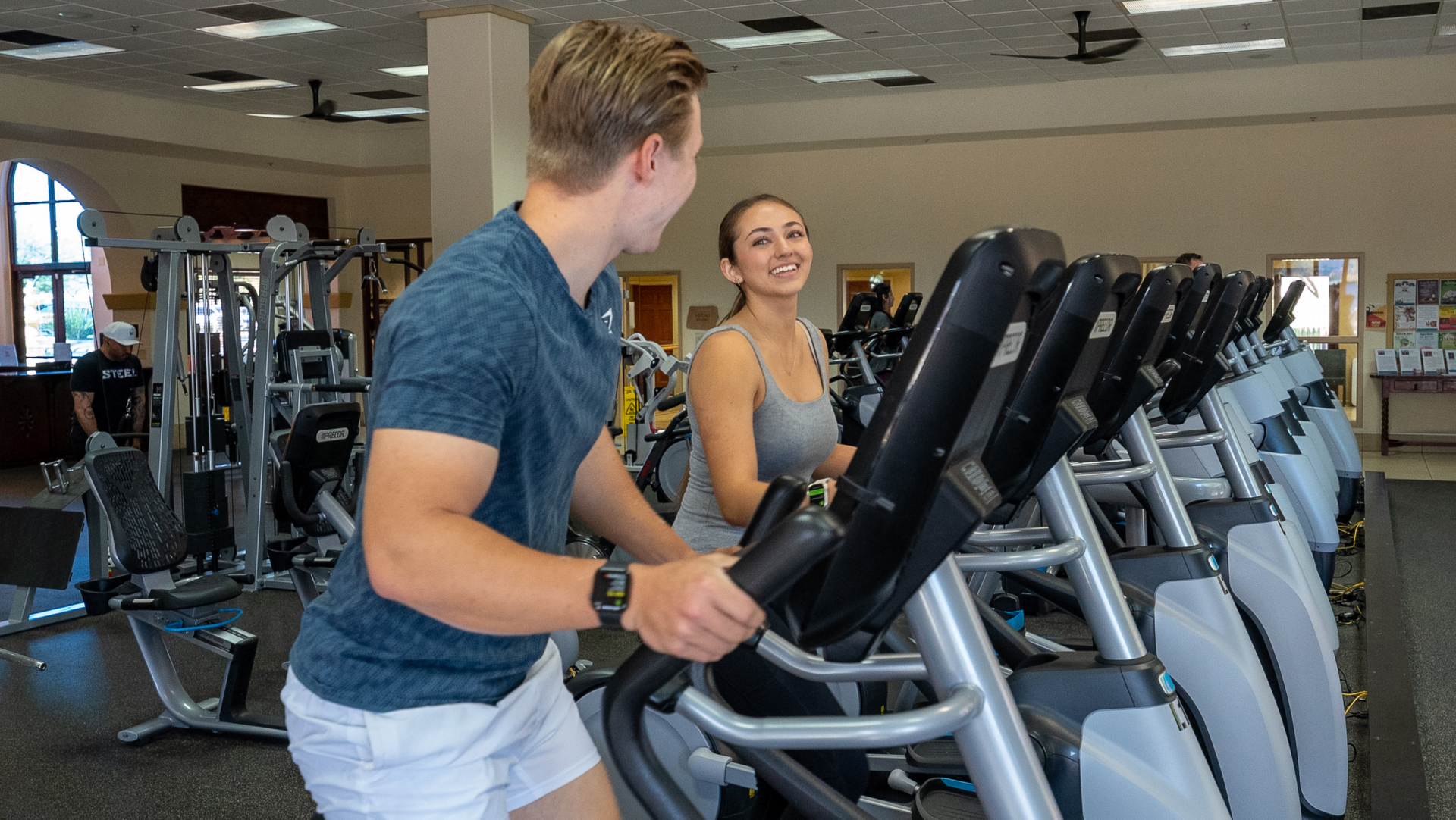 Young couple using cardio equipment at a fitness center in an Arizona master planned community
