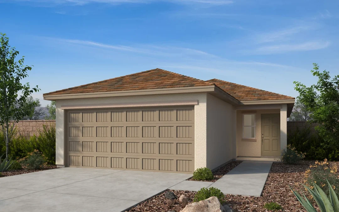 Single-story house with a two-car garage, light tan exterior, brown shingle roof, concrete driveway, and xeriscaped front yard with rocks and desert plants under a blue sky.